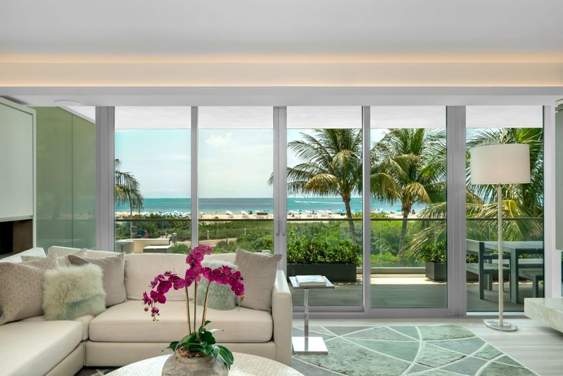 Living room behind floor-to-ceiling glass facing the ocean at Beach House 200, 321 Ocean Drive, Miami Beach — photo 2 of 8