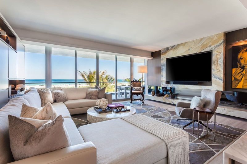 Living area with ocean views through the glass walls at Beach House 200, 321 Ocean Drive, Miami Beach — photo 3 of 8