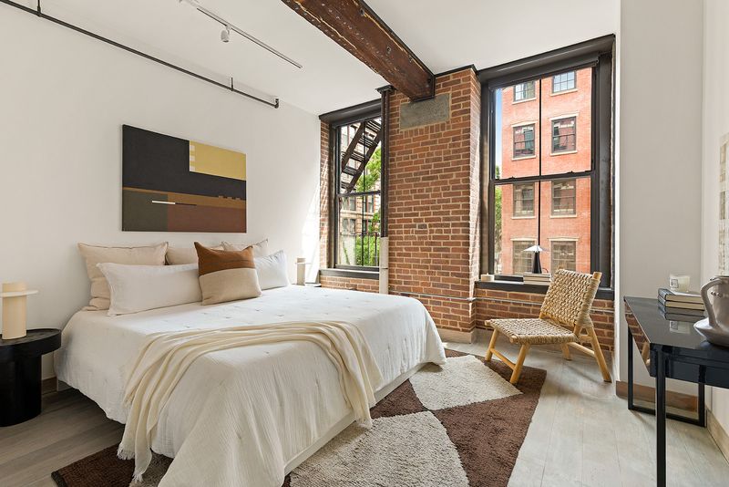 Primary bedroom with exposed brick at 33 Bleecker Street 3B, NoHo — photo 7 of 9