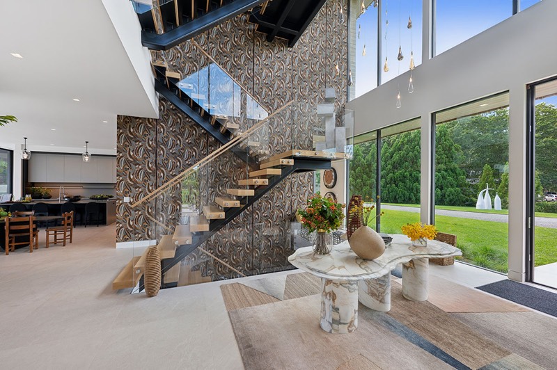 Two-story foyer with floating steel staircase at 392 Seven Ponds Towd Road, Water Mill — photo 3 of 10