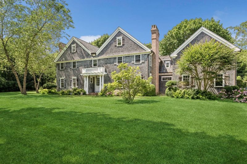 Cedar-shingled front elevation across the lawn at 5 New Lane, Southampton