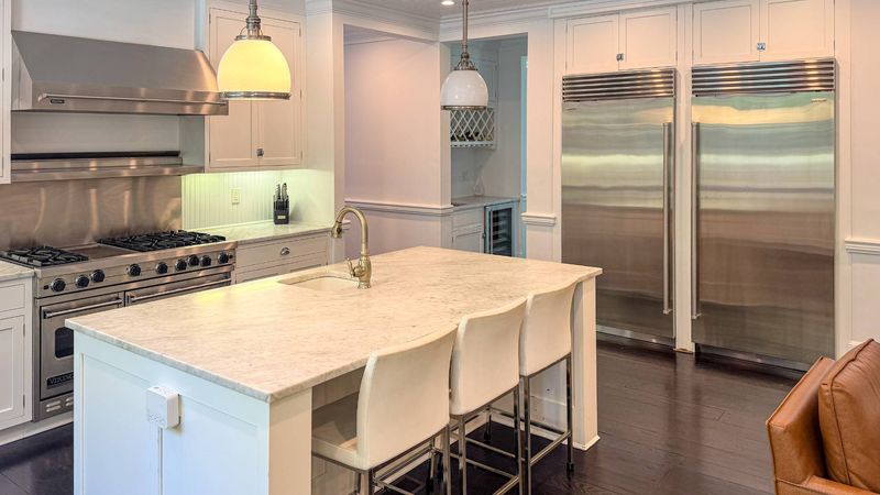 White kitchen with marble island and range at 5 New Lane, Southampton — photo 5 of 12