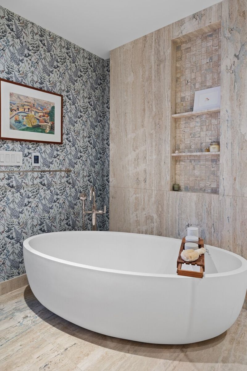 Primary bath freestanding soaking tub with travertine slab walls at 50 Bridge Park Drive 16B, Brooklyn Heights — photo 7 of 12
