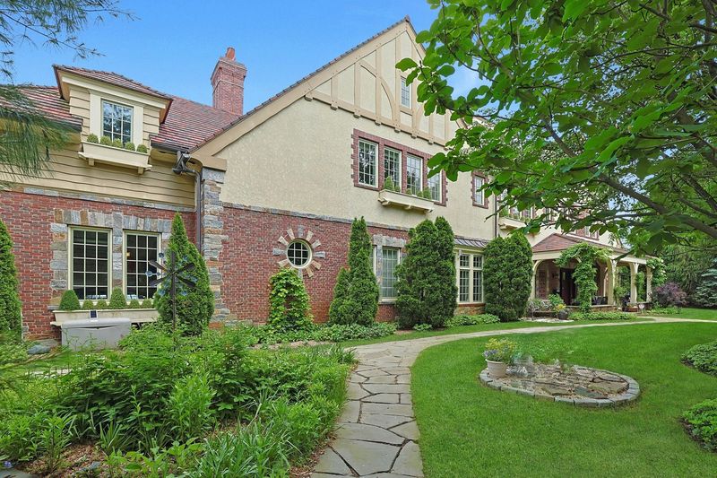 Front elevation in stone, brick and stucco with the garden path at 5020 Iselin Avenue, Riverdale — photo 2 of 7