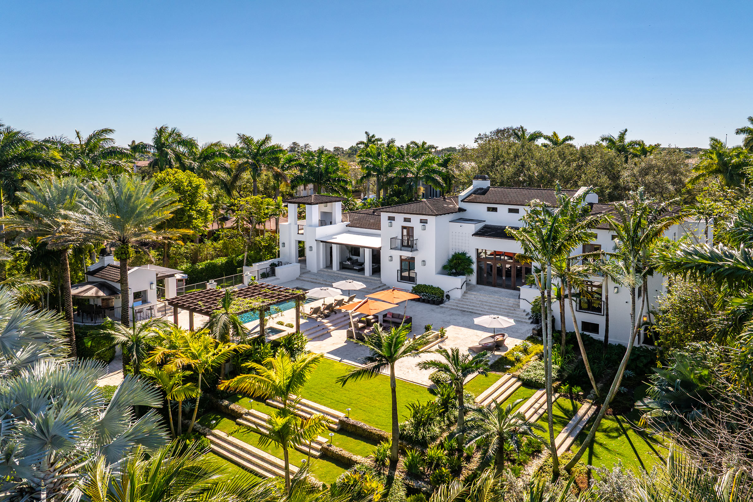rear facade, pool, and garden at 555 Arvida Parkway