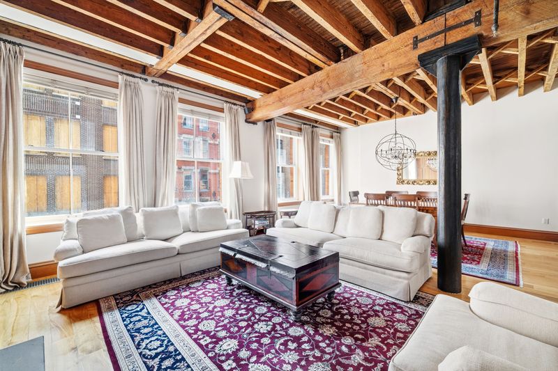 Great room with cast-iron column and beamed ceiling at 61 North Moore Street 3W, Tribeca
