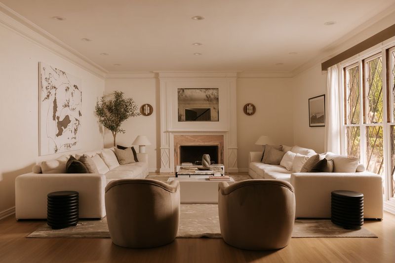 The living room, with a fireplace and French doors at 628 North Sierra Drive, Beverly Hills — photo 3 of 8
