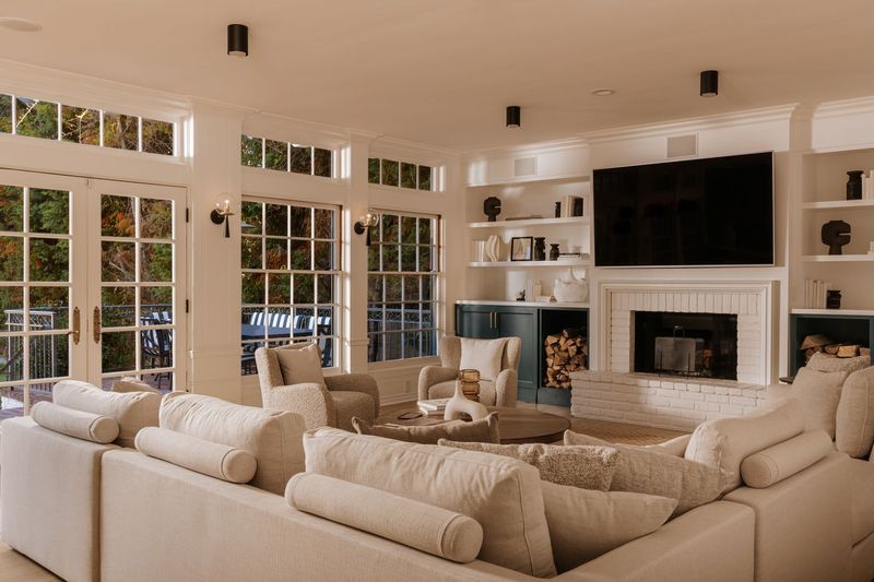 The family room, with a fireplace and a wall of French doors at 628 North Sierra Drive, Beverly Hills — photo 6 of 8