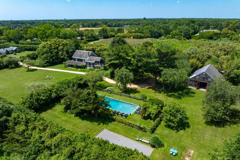 Aerial of the house, barn and pool within the hedged grounds at 645 North Sea Mecox Road, Southampton — photo 4 of 12
