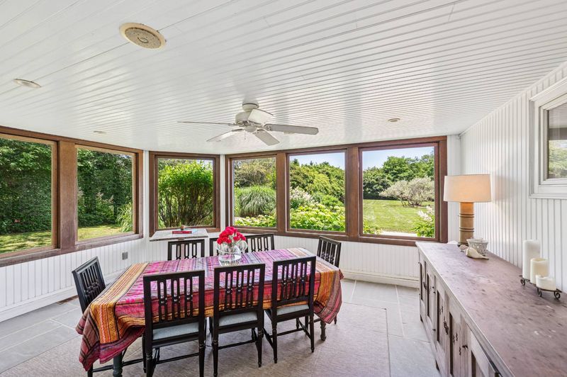 Year-round dining porch with garden-view windows at 645 North Sea Mecox Road, Southampton — photo 9 of 12