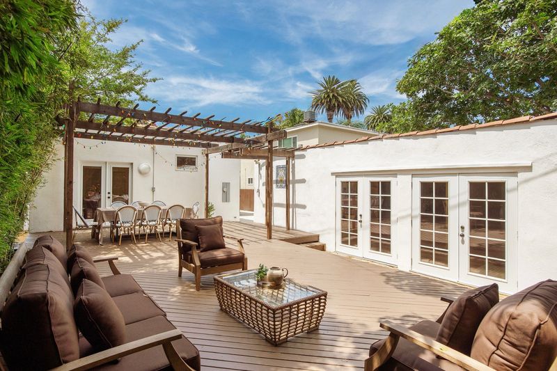 Private backyard deck under a pergola, with French doors opening to the garden at 718 Westbourne Drive, West Hollywood