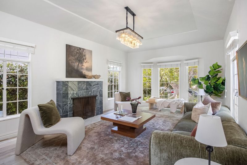 Living room with a fireplace and garden-facing windows at 718 Westbourne Drive, West Hollywood — photo 2 of 5