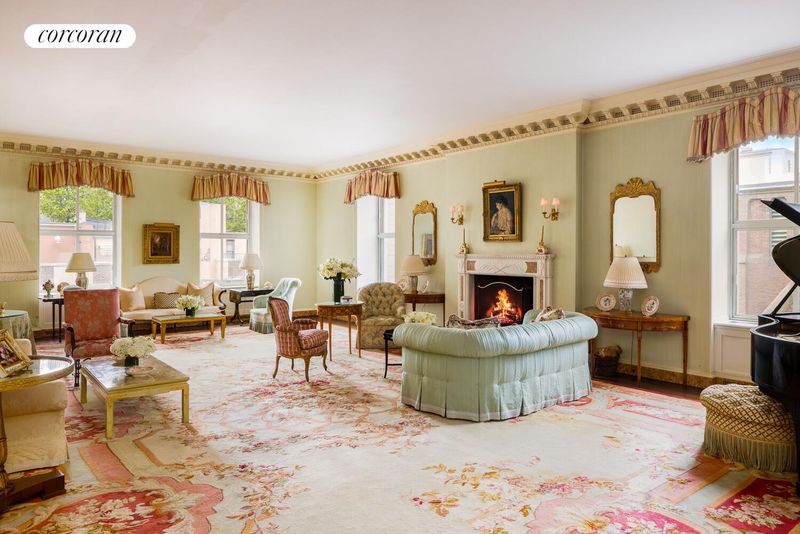 Corner living room with wood-burning fireplace and south-facing windows at 740 Park Avenue 6/7D, Lenox Hill