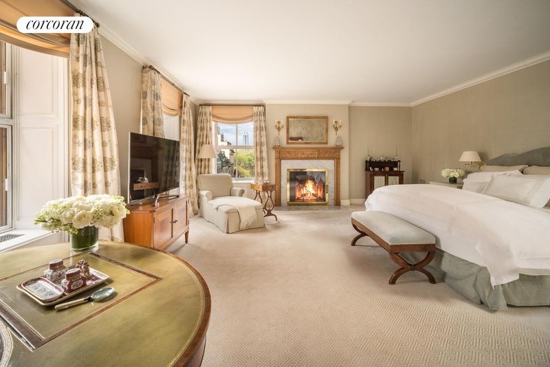Primary bedroom with the home's third wood-burning fireplace at 740 Park Avenue 6/7D, Lenox Hill — photo 7 of 12