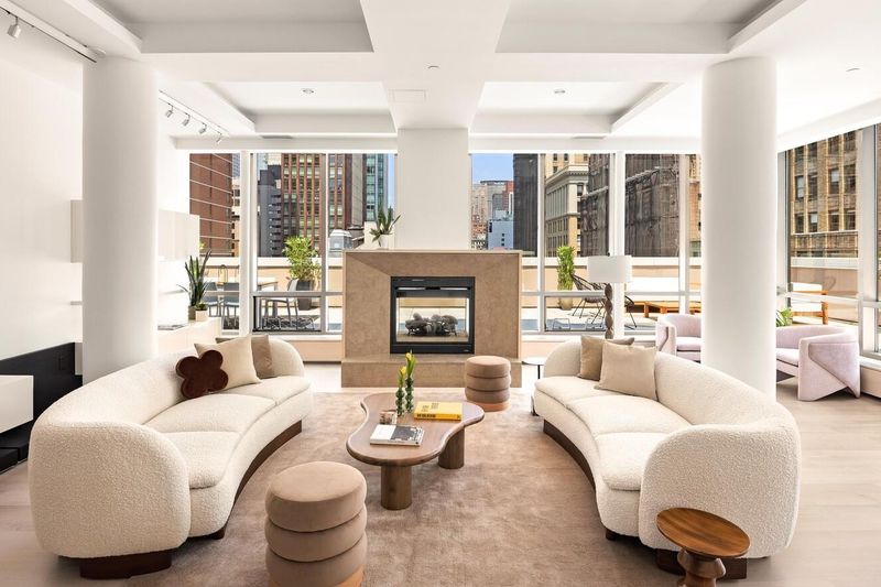 Living area with two curved sofas at 76 Madison Avenue PH1, NoMad — photo 2 of 8