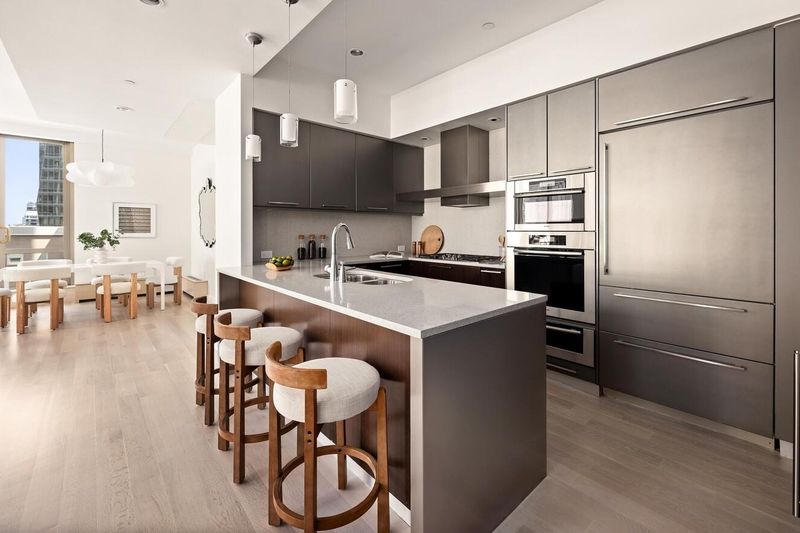 Open kitchen with dark-gray island at 76 Madison Avenue PH1, NoMad — photo 4 of 8