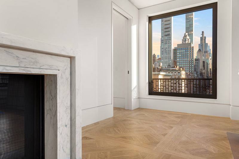 Great room with Calacatta Caldia marble fireplace and Versailles-pattern oak floors at 760 Madison Avenue, Ninth Floor, Lenox Hill