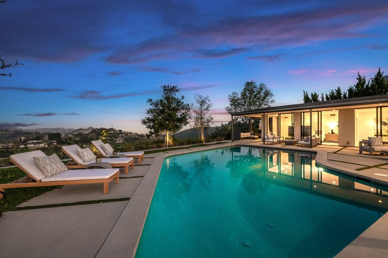 Pool at sunset with city and hills beyond at 8545 Charl Lane, Hollywood Hills — photo 2 of 8