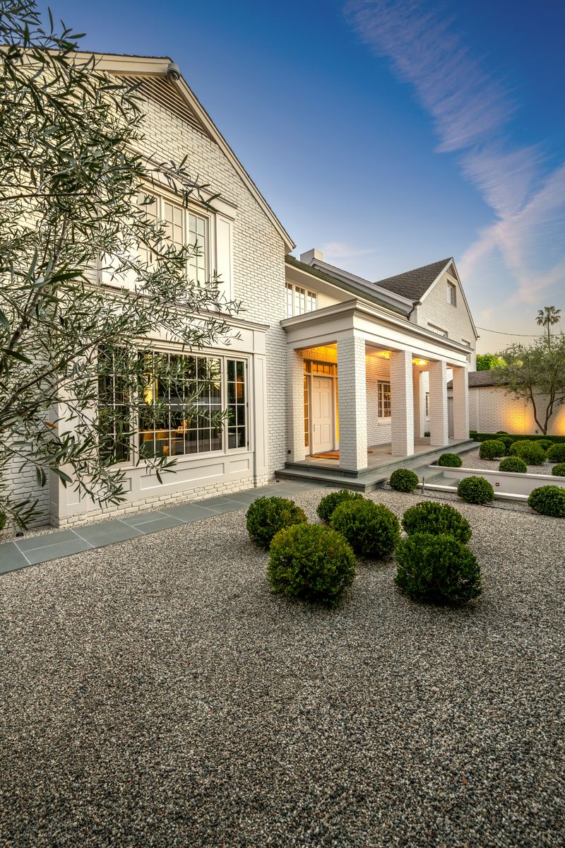 Courtyard arrival at dusk with boxwood and gravel at 9551 Lime Orchard Road, Beverly Hills — photo 3 of 8