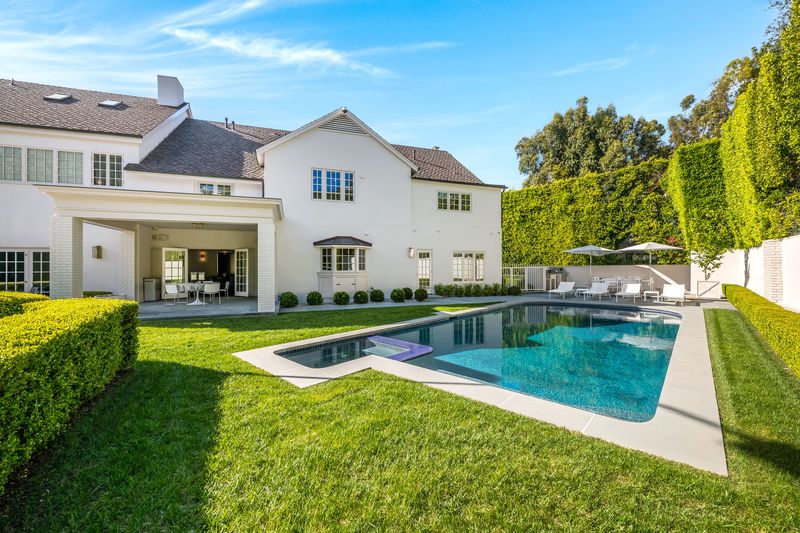 Rear facade over the rectangular pool and lawn at 9551 Lime Orchard Road, Beverly Hills — photo 8 of 8